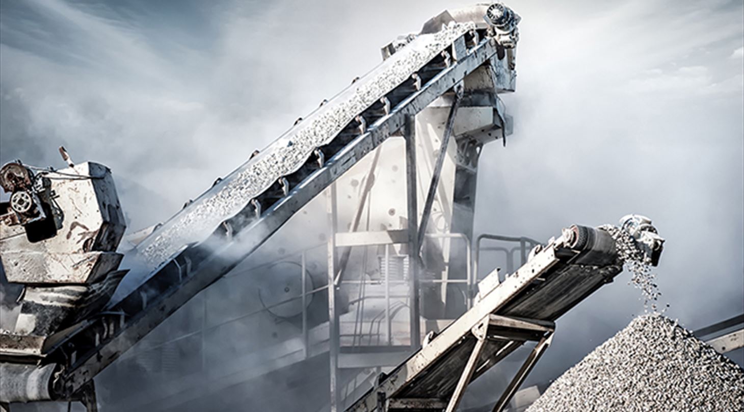Billedet viser et udsnit af en cementproduktion - et todelt transportbånd. Billedet er brugt i Plast og Emballages Medlemsinformation nr. 3-25